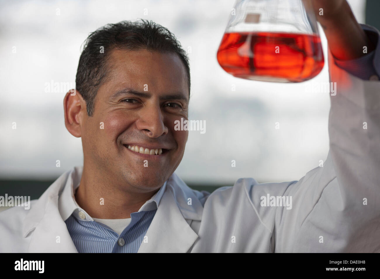Mature scientist looking at liquid fiole en Banque D'Images