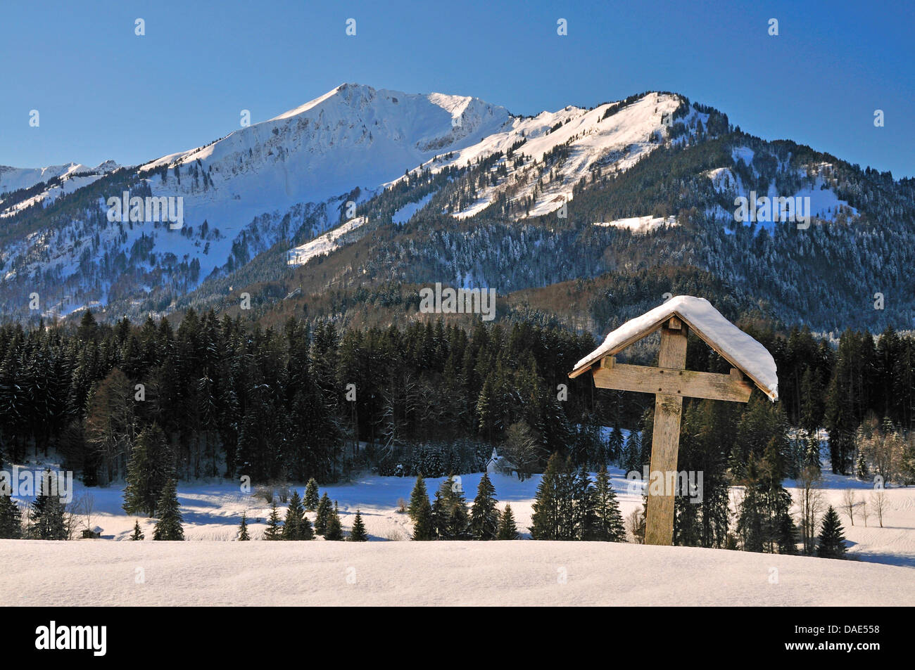 Croix sur le terrain en face de la montagne enneigée paysages, Allemagne, Bavière, Allgaeu, Oberstdorf Banque D'Images