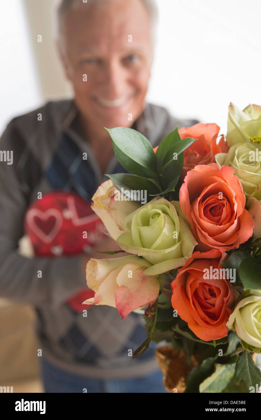 Senior man holding bouquet de fleurs et chocolats Banque D'Images