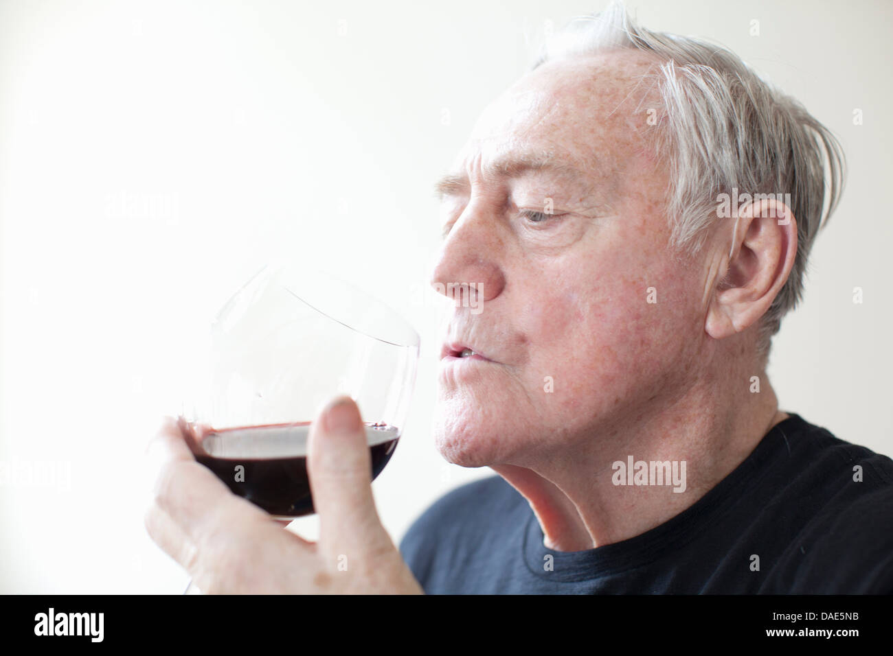 Senior man drinking red wine Banque D'Images