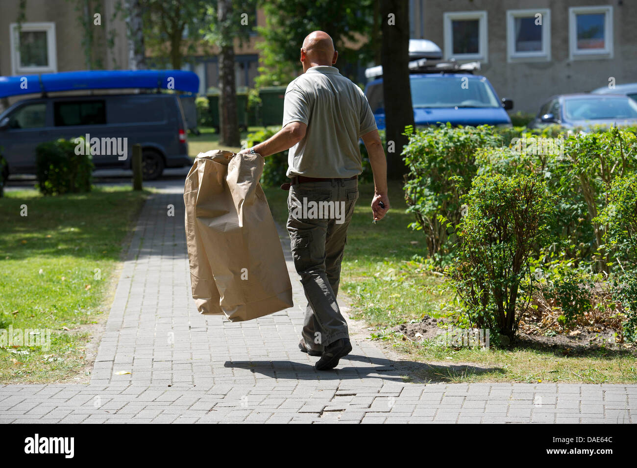 Un officier de police judiciaire prend des morceaux de preuve hors de l'immeuble où un homme a été arrêté dans le cas de l'assassinat de Anna-Lena dans Luebeck-Eichholz, Allemagne, 11 juillet 2013. Quatre jours après le meurtre violent d'un jogger Luebeck dans une forêt près de Herrnburg, un homme de 46 ans a été arrêté. Photo : OLAF MALZAHN Banque D'Images