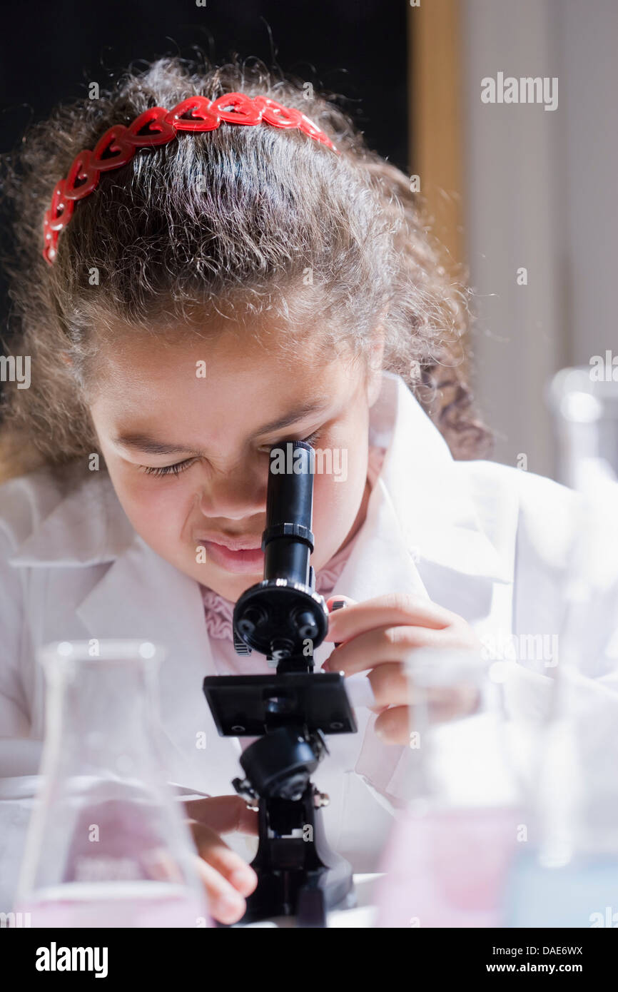 Girl using microscope Banque D'Images