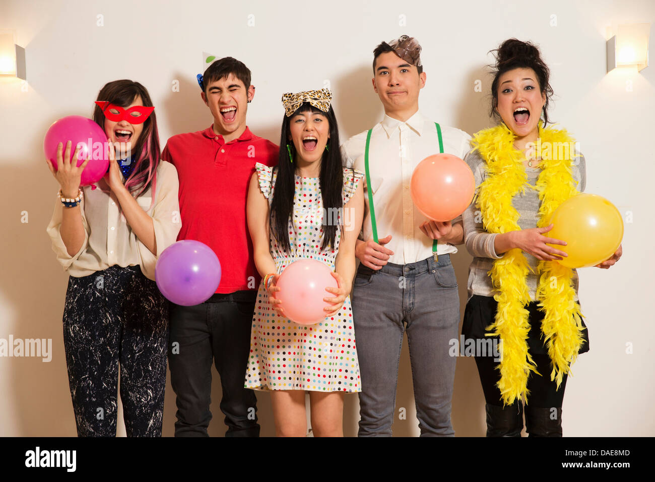 Les amis à une fête avec des ballons, studio shot Banque D'Images