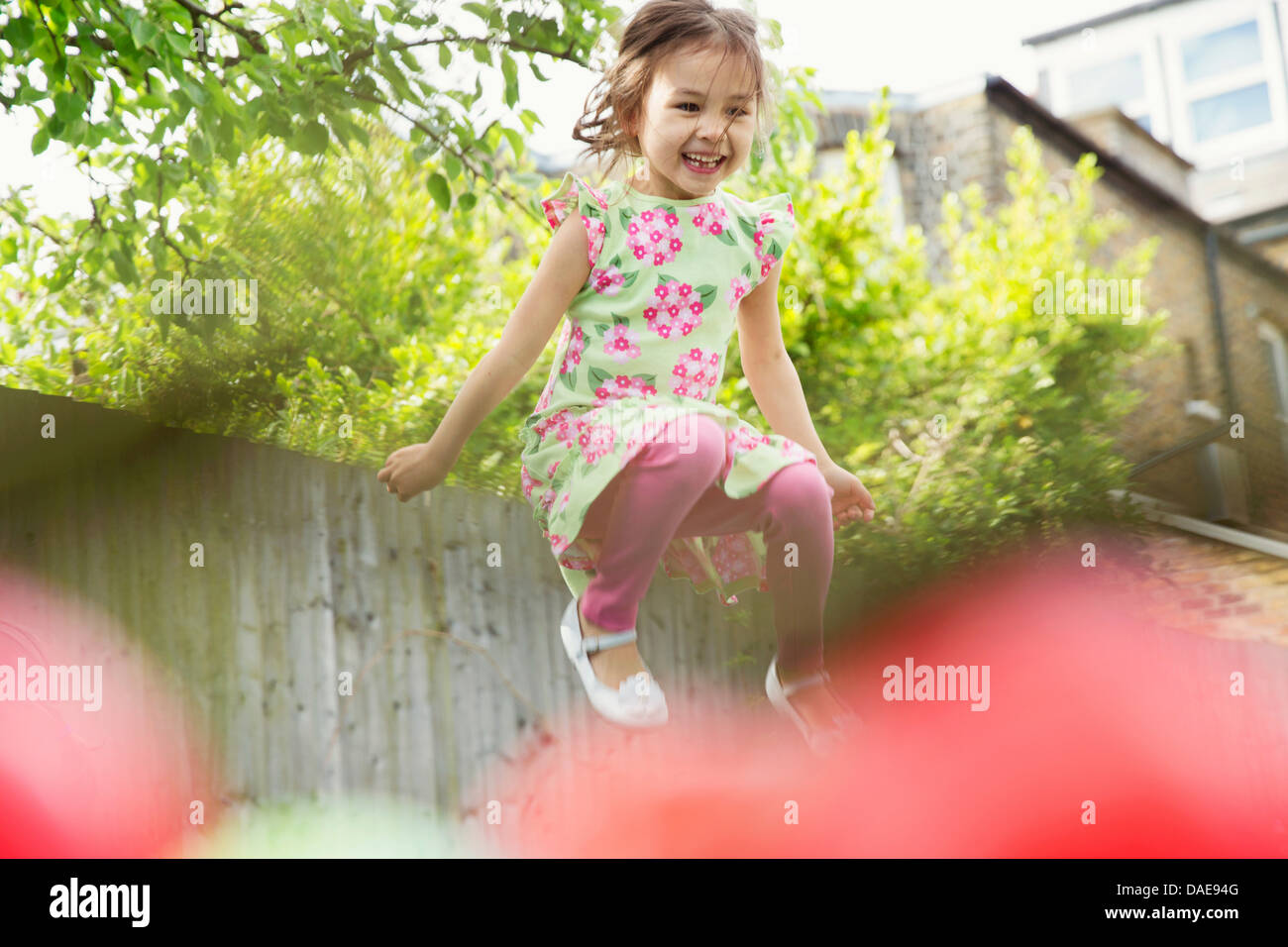 Young Girl jumping mid air in garden Banque D'Images
