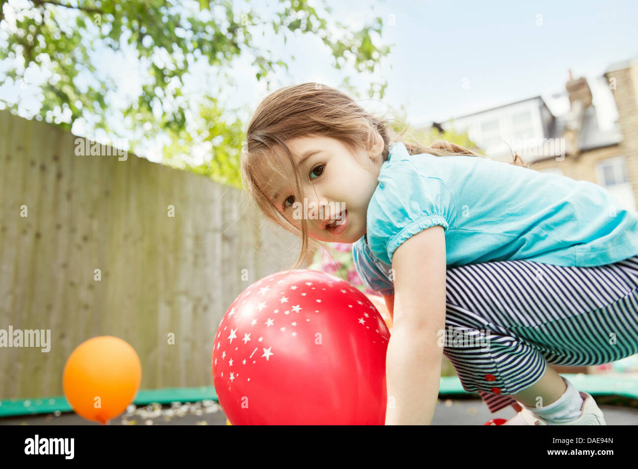 Young Girl playing in garden with balloons Banque D'Images