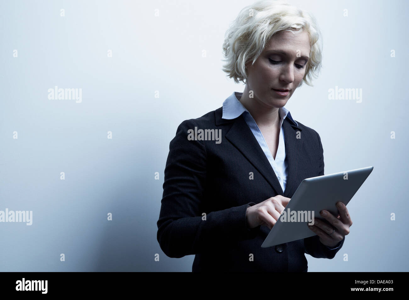Studio portrait of blond businesswoman with digital tablet Banque D'Images