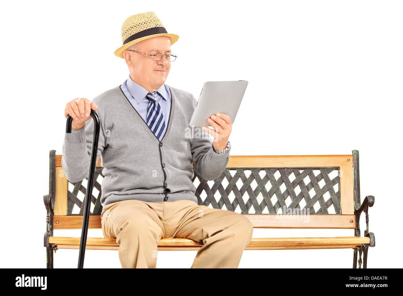 Hauts homme assis sur un banc en bois et la lecture d'une tablette Banque D'Images