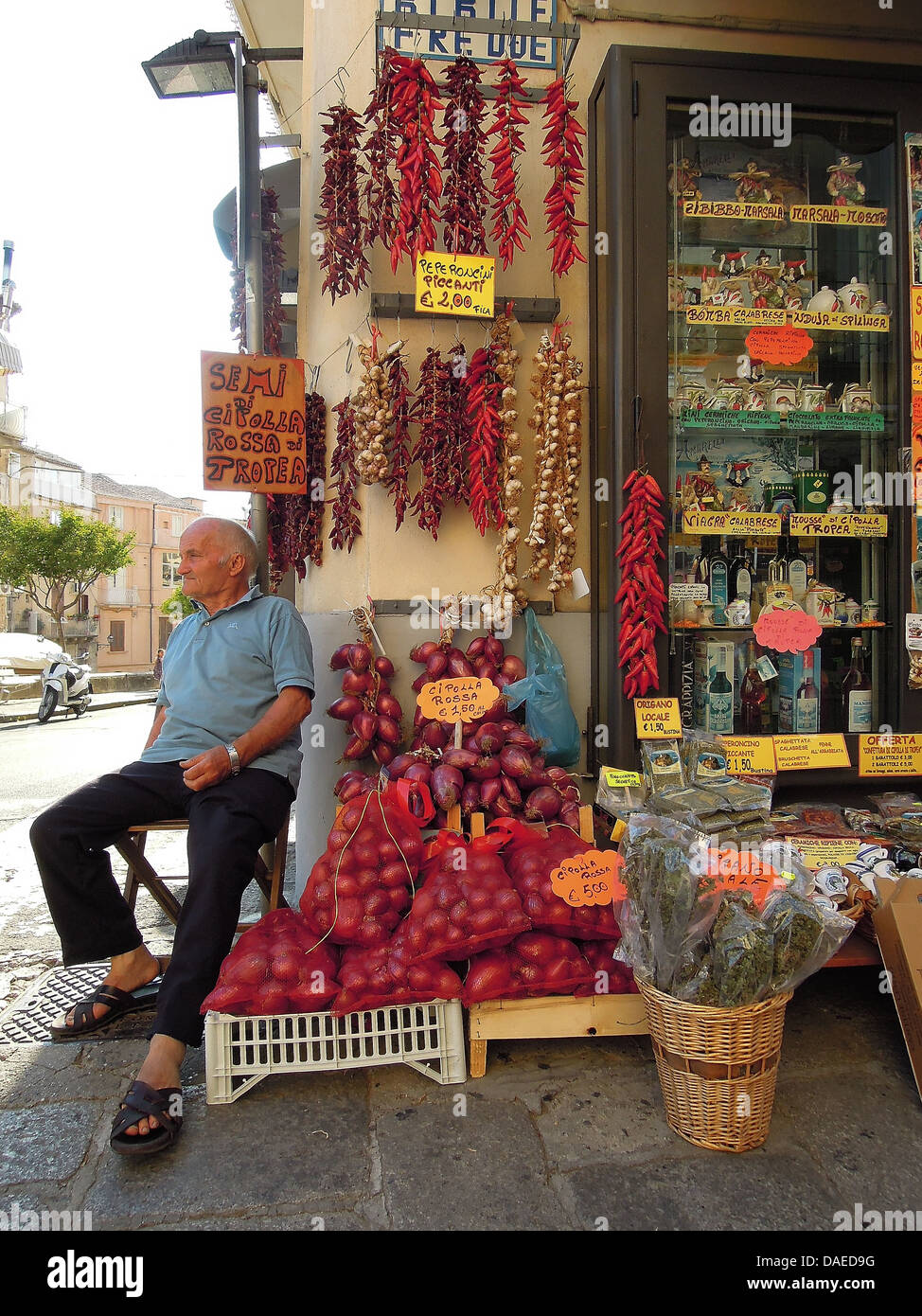Vieil homme assis devant un magasin, l'Italie, Calabrien, Tropea Banque D'Images