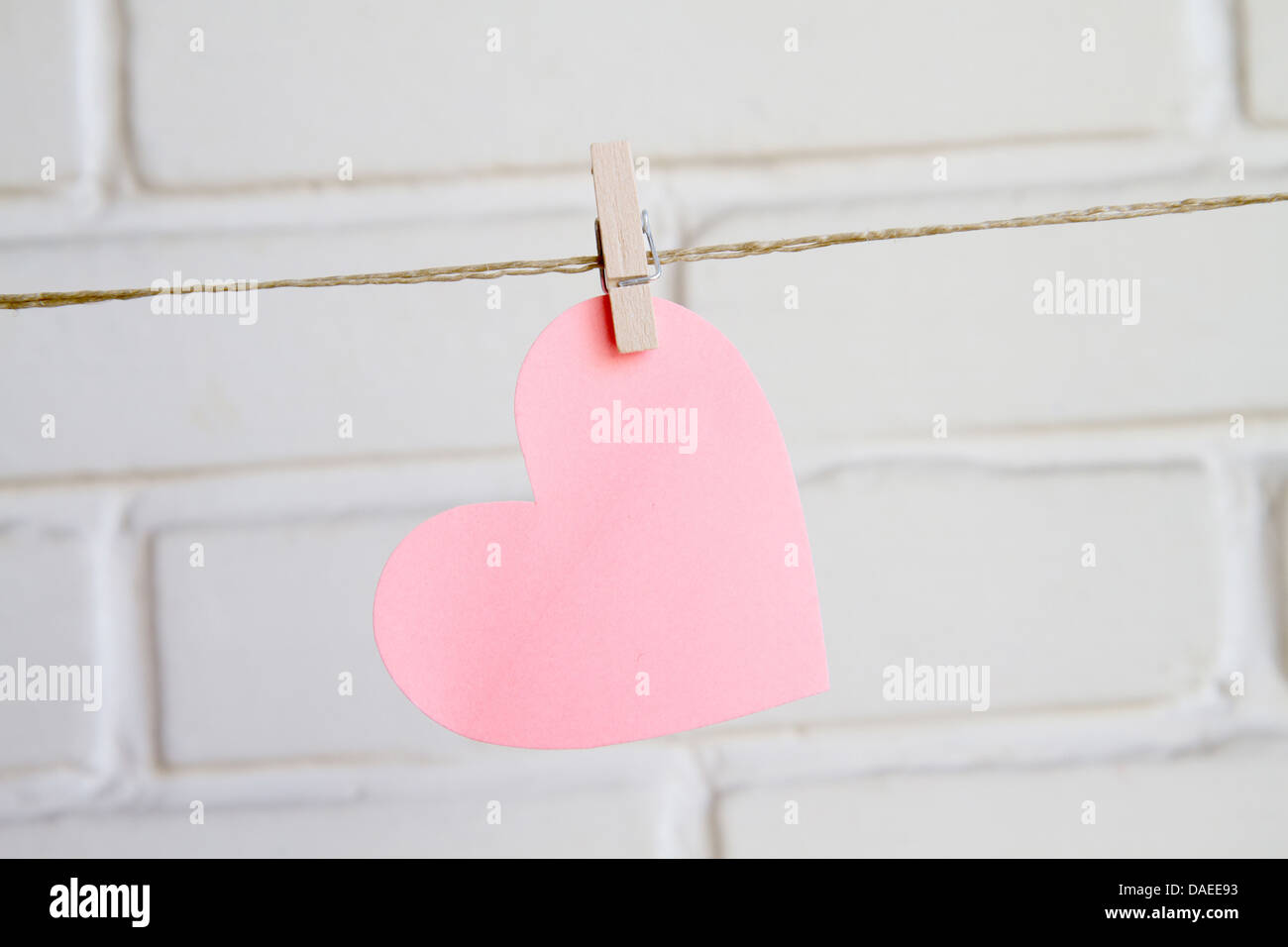 Coeur avec clothespin sur fond blanc wall Banque D'Images