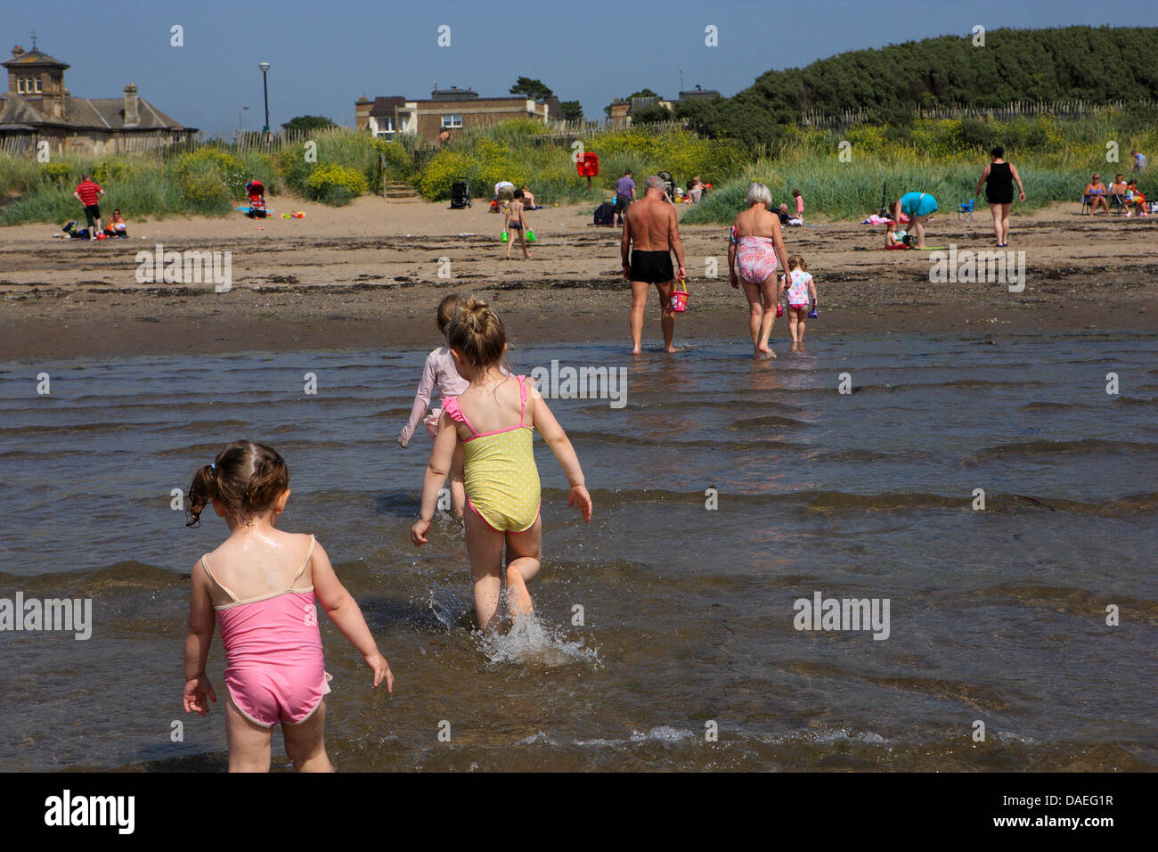 Troon, Ayrshire, Scotland, UK. 11 juillet 2013. Les enfants jouent dans la mer à la plage de Troon Ayrshire, avec le beau temps continue et les familles affluent vers les plages pour profiter de la canicule. Credit : PictureScotland/Alamy Live News Banque D'Images