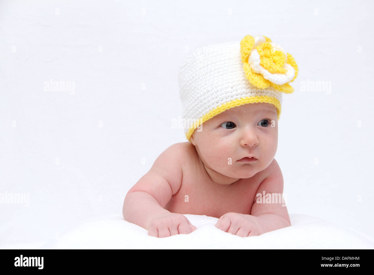 Bébé avec un chapeau blanc tricoté avec fleur jaune Banque D'Images