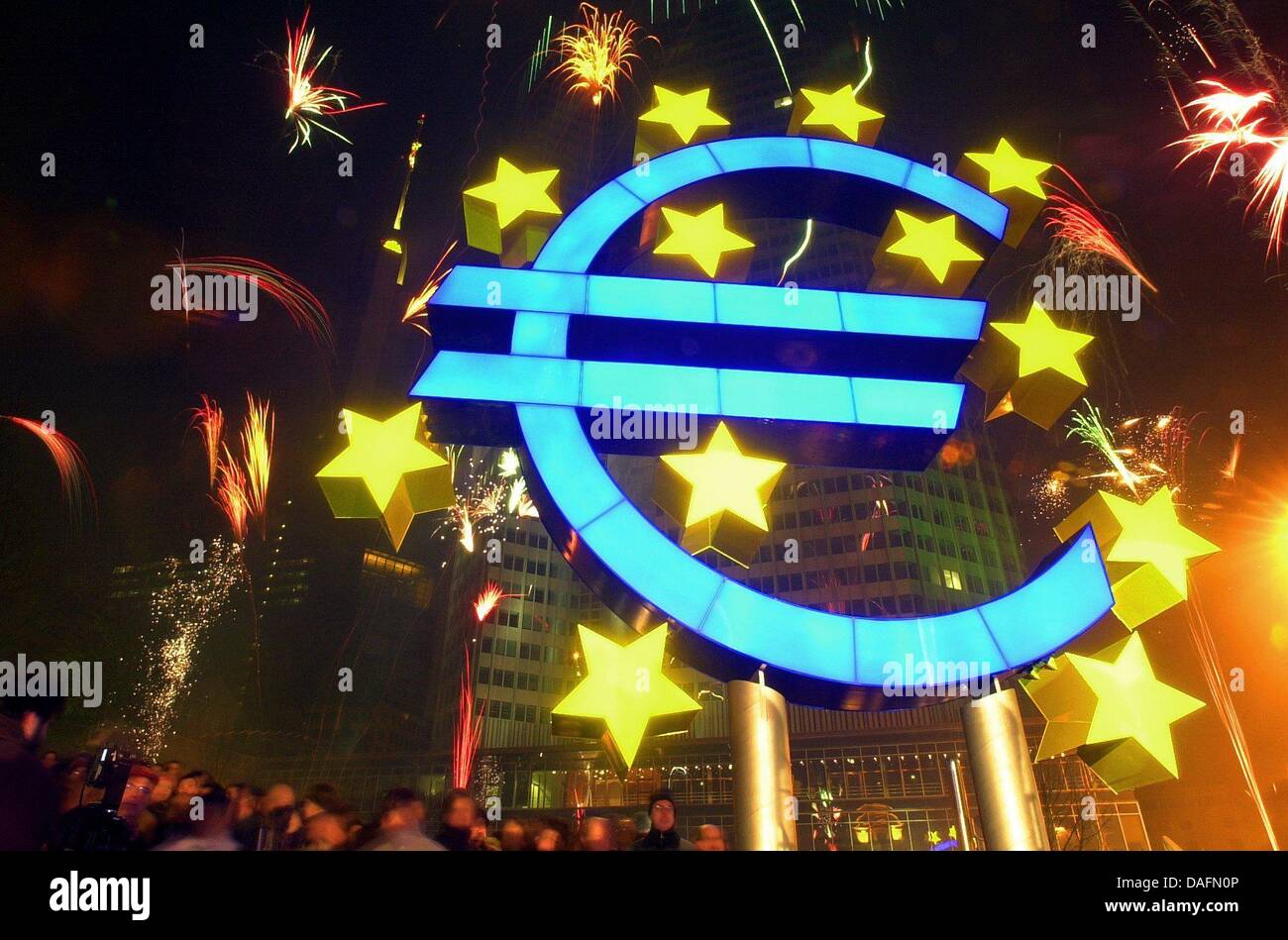 (Afp) - Un fichier photo en date du 01 janvier 2002 montre d'artifice derrière une sculpture à l'euro La Banque centrale européenne à Francfort en Allemagne. Plusieurs milliers de personnes se sont joints pour célébrer l'inauguration de l'euro à Francfort. Même dix ans plus tard, l'euro est encore largement considérée comme ayant rendu la vie plus chère et ses partisans pense que c'est une excellente idée. Photo : Banque D'Images