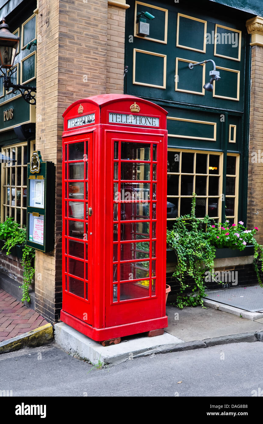 Cabine téléphonique rouge à côté d'une pub Banque D'Images