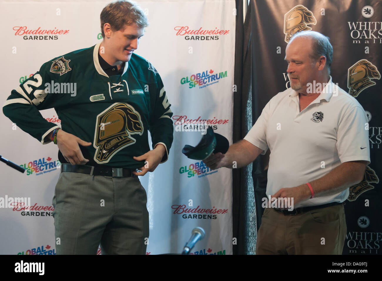 London, Ontario, Canada. 12 juillet 2013. Les spéculations entourent où Michael McCarron jouera cette saison a été mis à l'ensemble lorsque la 6'5' de l'avant a glissé sur un jersey Les Knights de London lors d'une conférence de presse le 12 juillet 2013 à London, en Ontario, Canada. Rédigé par les Canadiens de Montréal de la Ligue Nationale de Hockey, McCarron a signé un contrat avec le club de la LNH au début de la semaine, il n'aurait pas de signalisation à la Western Michigan University. Credit : Mark Spowart/Alamy Live News Banque D'Images