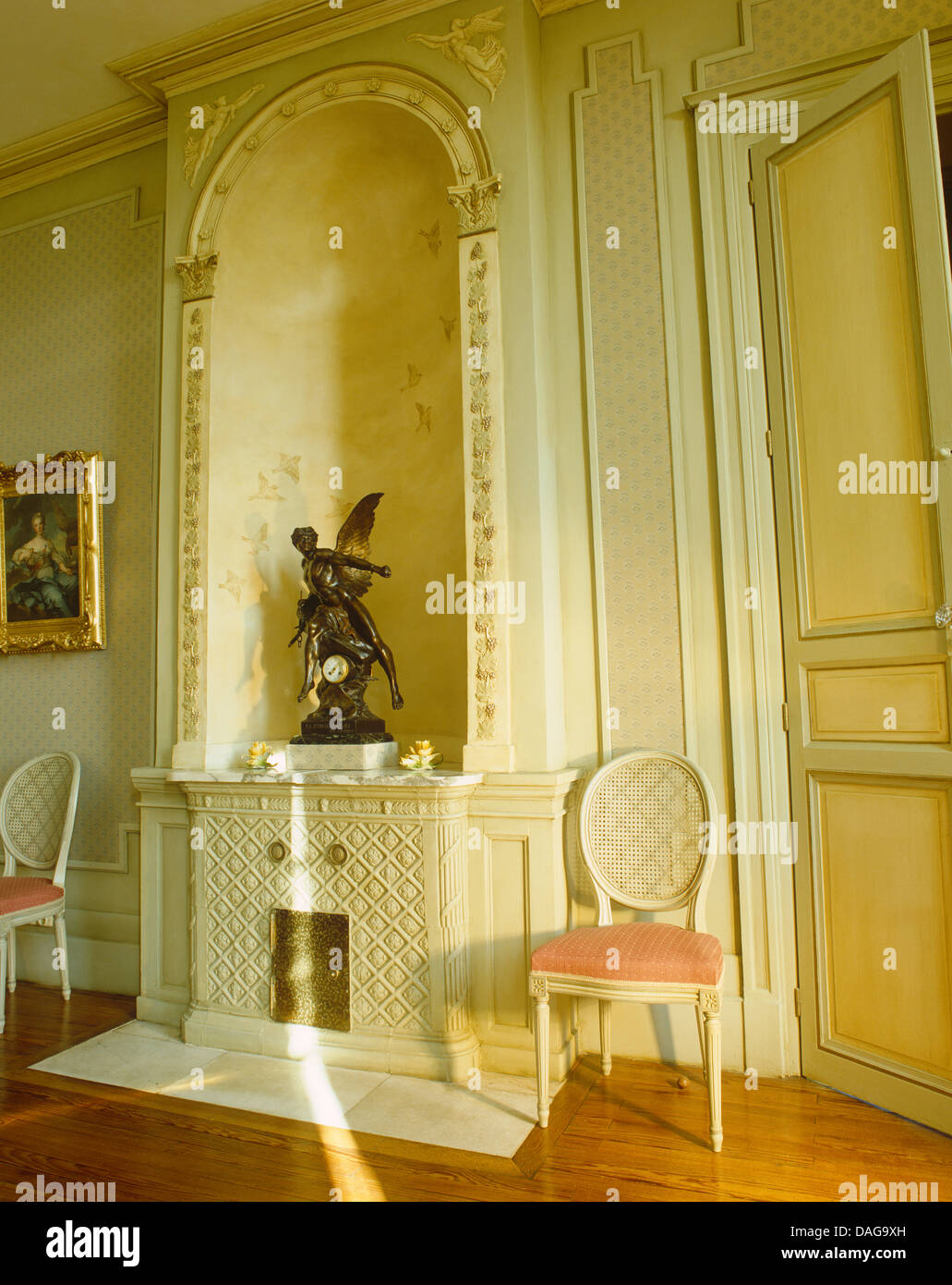 Statue de bronze dans une alcôve au-dessus de cheminée décorative en français pays salle avec chaises à ballon peint Banque D'Images