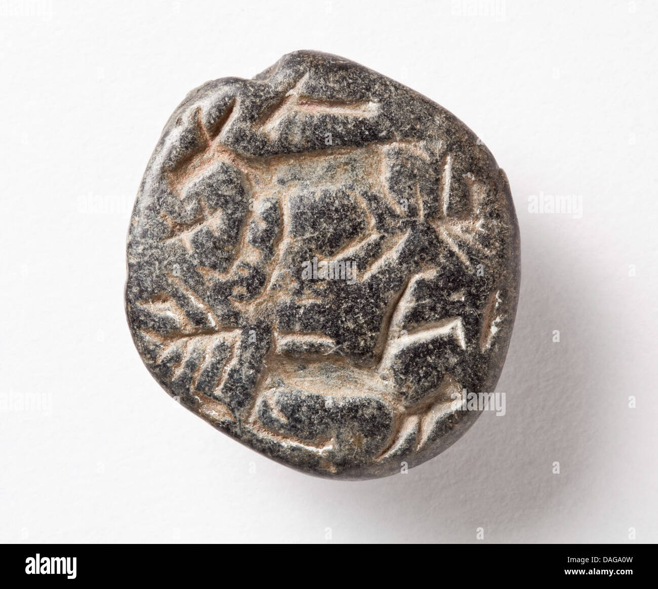 Ce sceau de timbre en forme de lentille a été utilisé pour graver et marquer des documents dans les cultures anciennes, avec des dessins complexes qui mettent en valeur les premières pratiques administratives et les traditions artistiques. Banque D'Images