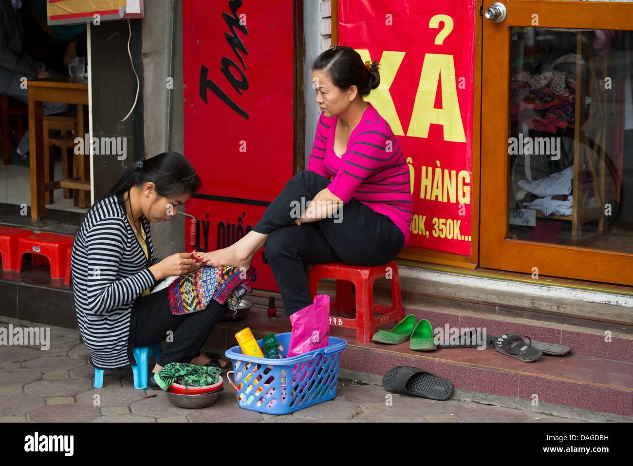 Vietnamienne faire pédicure dans les rues du vieux quartier de Hanoi, Vietnam Banque D'Images