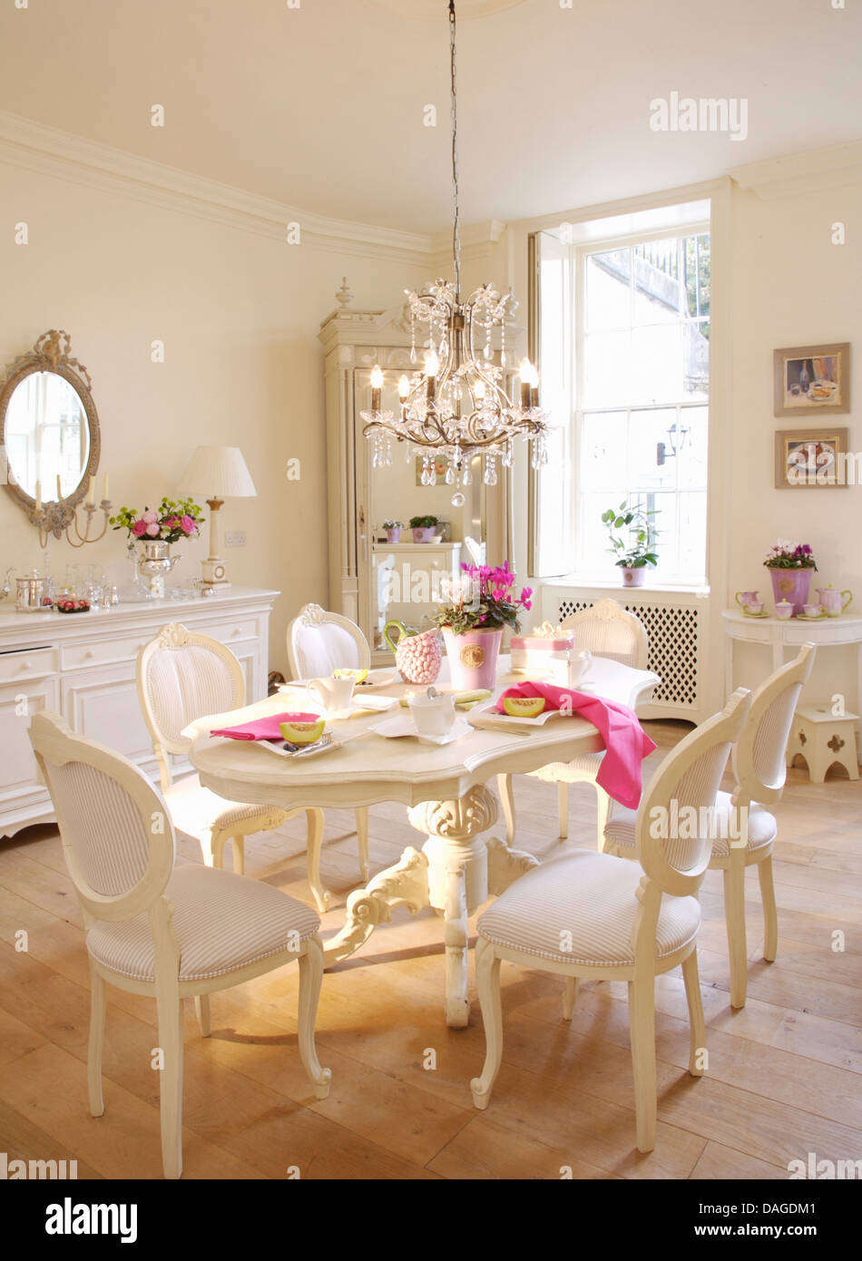 Chaises de style français blancs et peints en blanc table ovale de style gustavien en salle à manger avec plancher en bois et verre lustre Banque D'Images