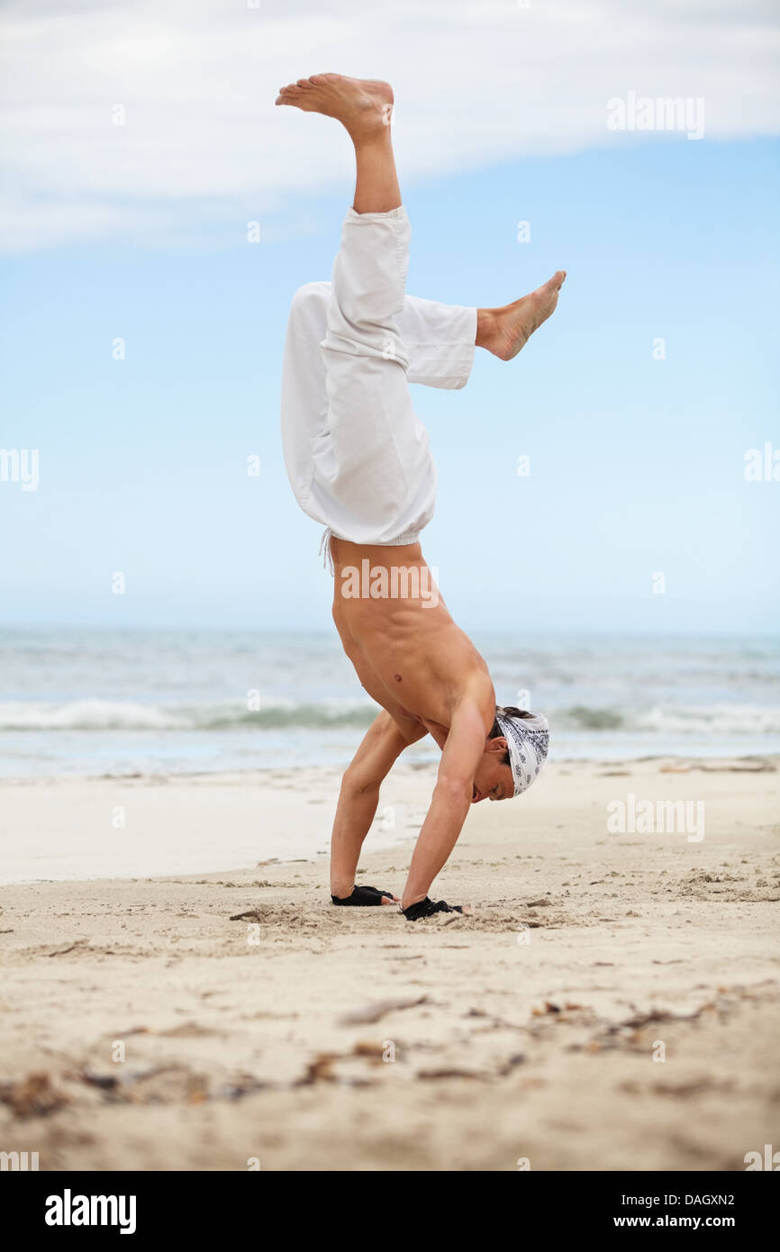 L'homme saute le Karaté sportif arts martiaux lutte kick jump beach summertime Banque D'Images