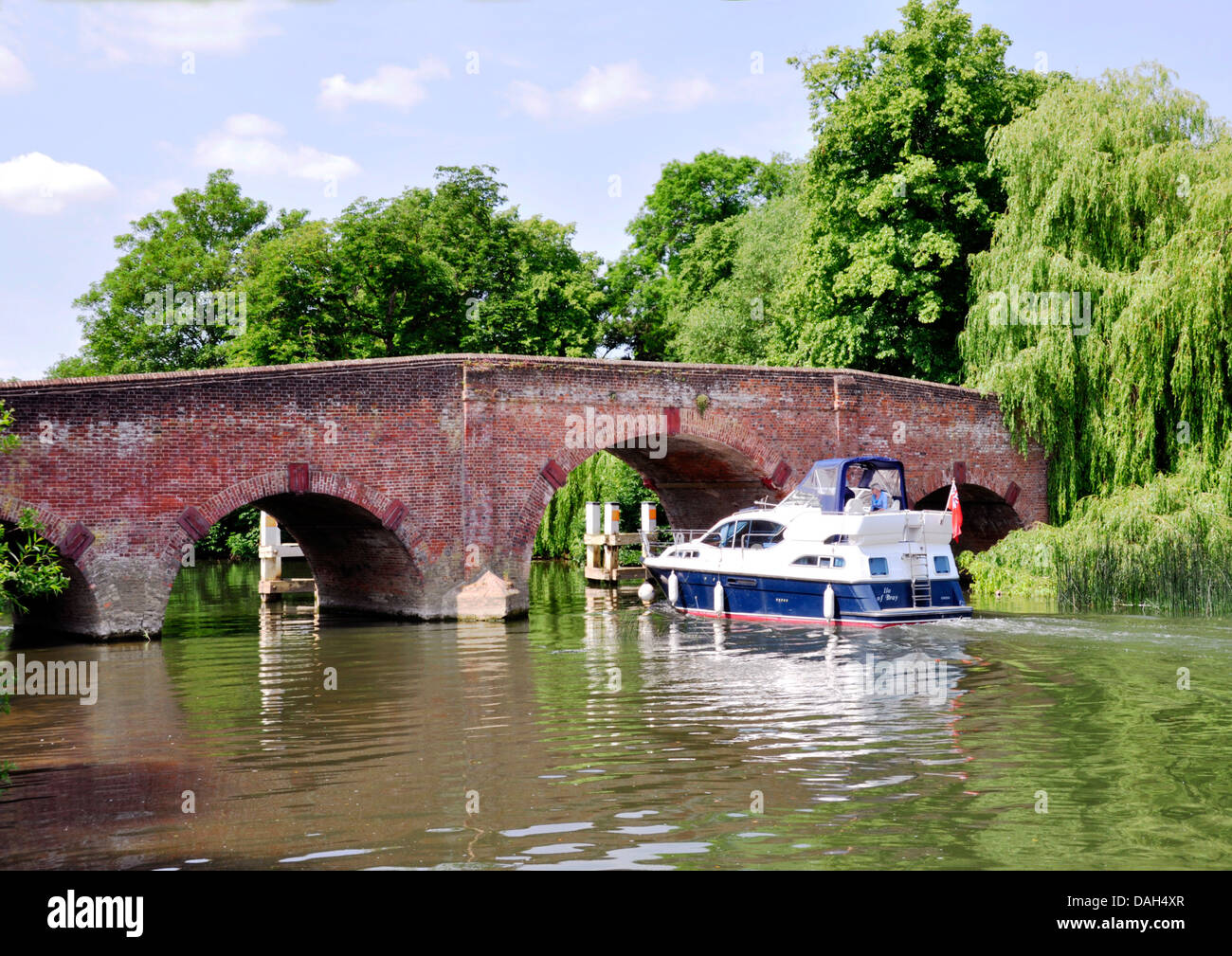 Berks - Sonning on Thames - plaisir cruiser à l'ancien pont - encadrée d'arbres - haut journée d'été - blue sky - les nuages - réflexions Banque D'Images