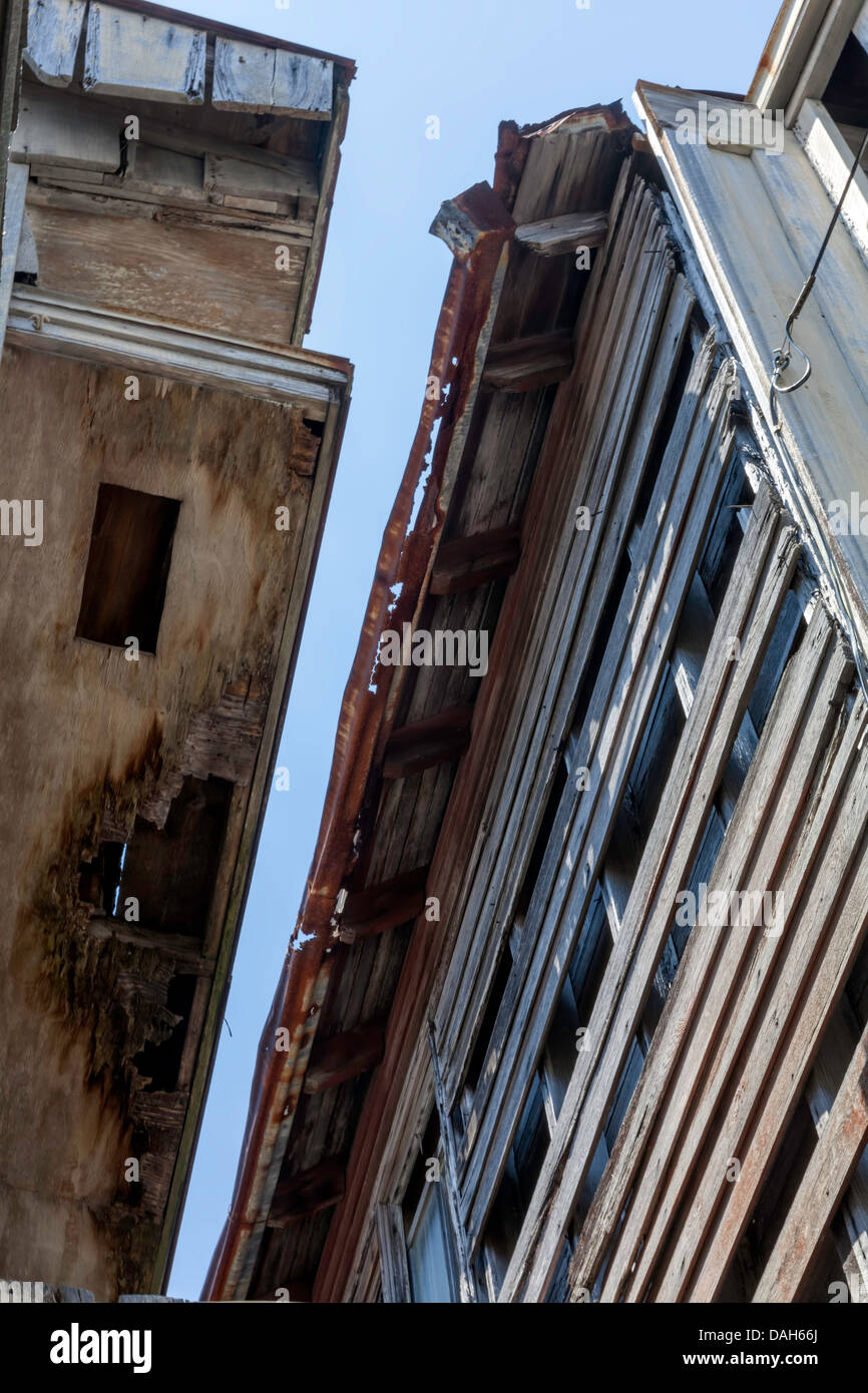 Les avant-toits, gouttières et haut des murs de deux bâtiments en ruine dans le quartier historique de Cedar Key montrent des dommages causés par l'eau. Banque D'Images