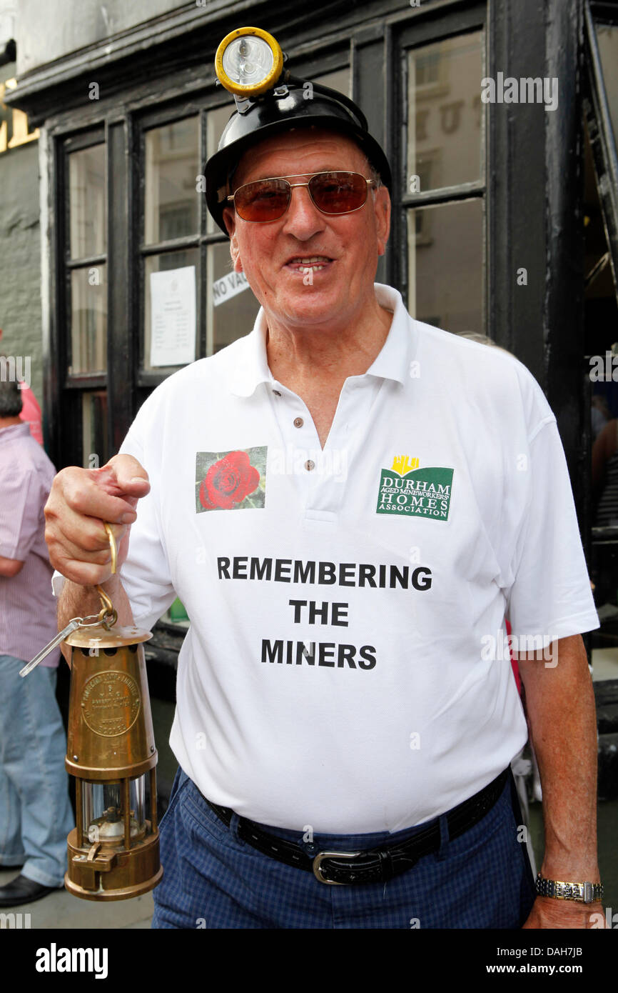 Un ex-mineur de la 129e Gala à mineurs de Durham Durham, Angleterre. L'homme porte un casque, porte une lampe et Davey a un slogan sur son T-shirt. Banque D'Images