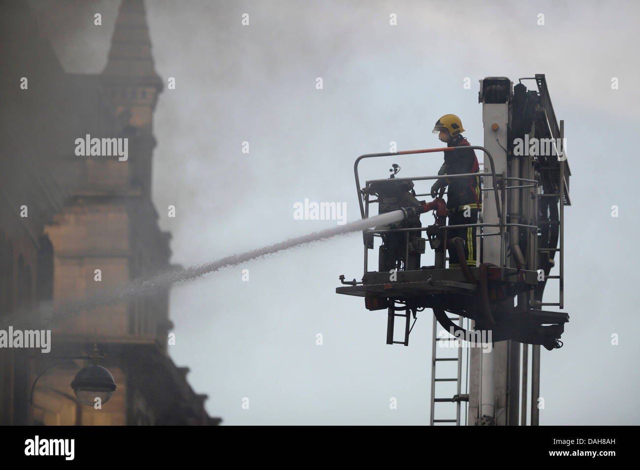 Manchester, UK. Le 13 juillet, 2013. Les pompiers s'attaquer à un blaze à Paul's Hair World et NQ Life music venue sur Oldham Street dans la zone quartier Nord de Manchester. pompier Stephen Hunt, 38 ans, est mort la lutte contre l'incendie. Deux adolescentes ont été arrêtés, soupçonnés d'homicide involontaire dans le cadre de l'incendie. Credit : Russell Hart/Alamy Live News (usage éditorial uniquement). Banque D'Images