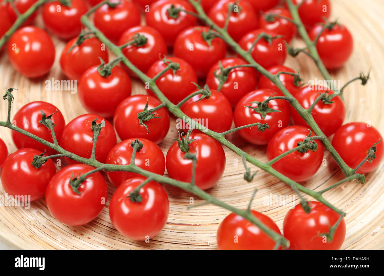 Tomates cerise sur la vigne placés dans un panier - faible profondeur de champ Banque D'Images