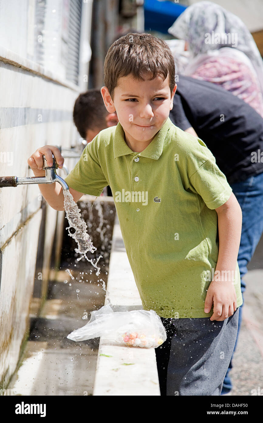 Petit garçon l'eau potable sur un marché local centre-ville de Manavgat - Turquie Banque D'Images