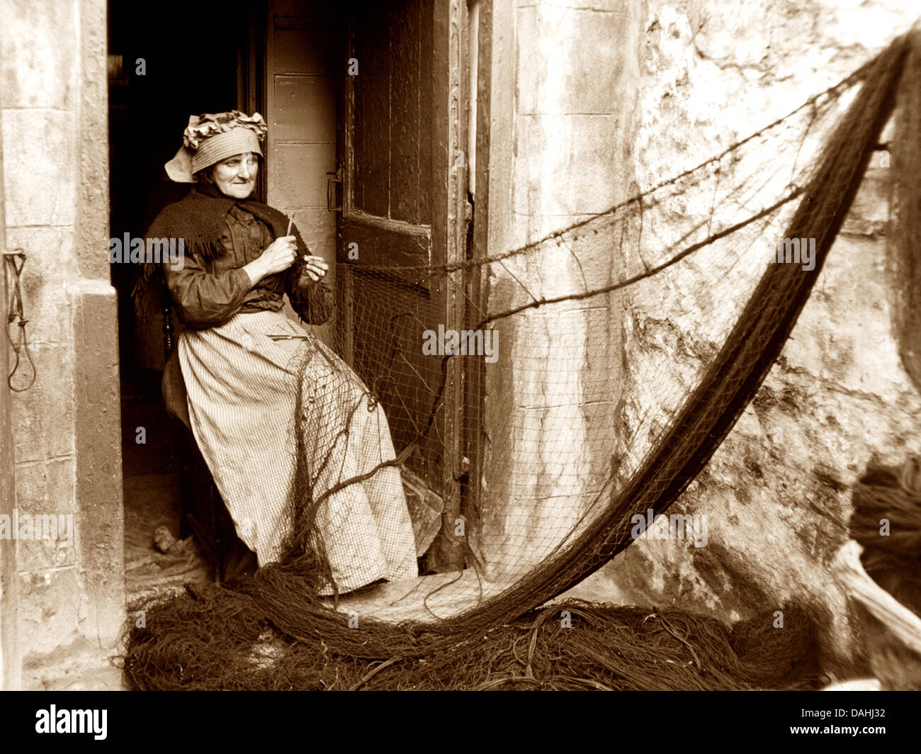Réparer les filets de pêche au début des années 1900 Photo Stock Alamy