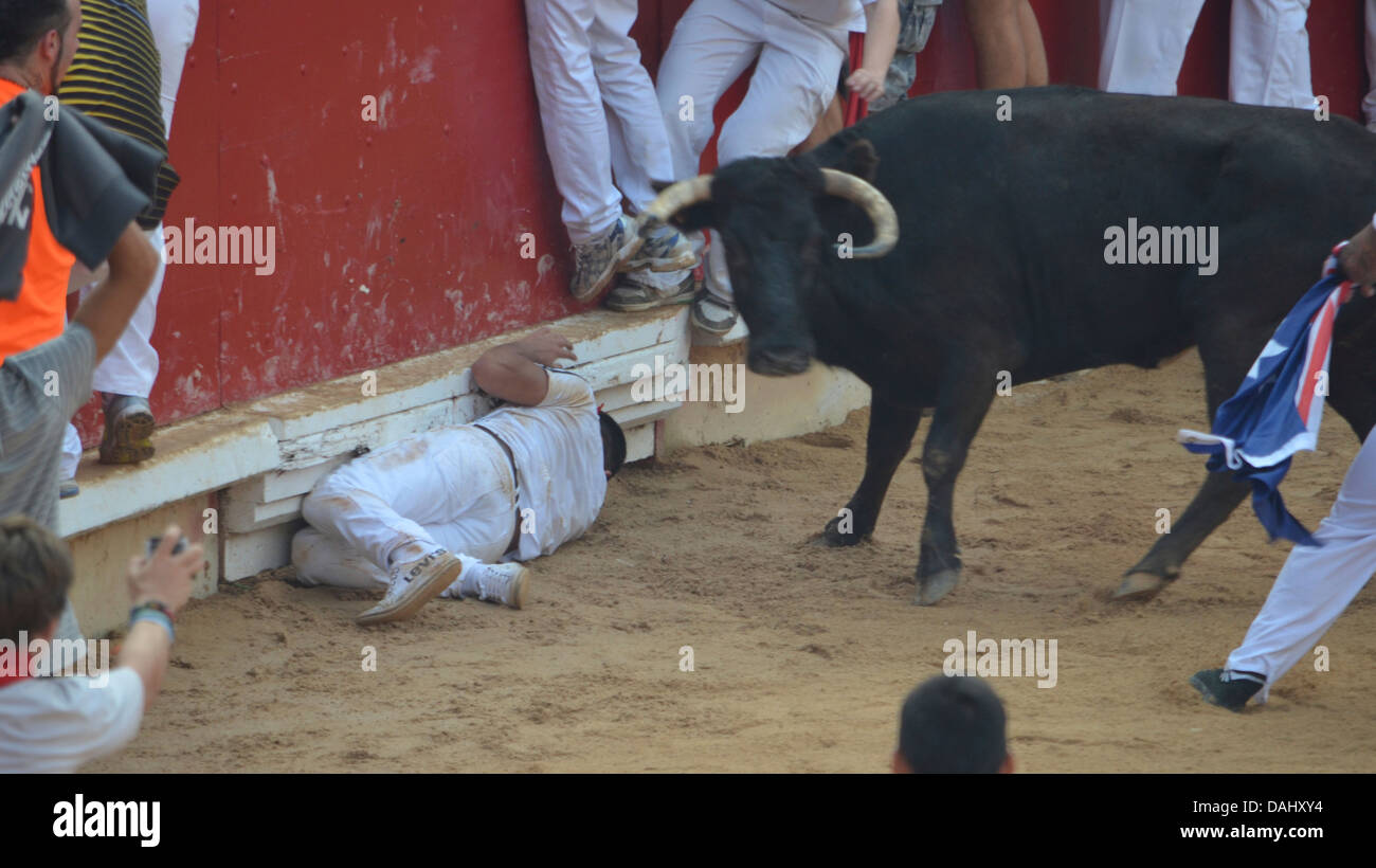 Des foules de gens auxquels un taureau à l'assemblée annuelle San Fermín à Pampelune, Espagne Banque D'Images