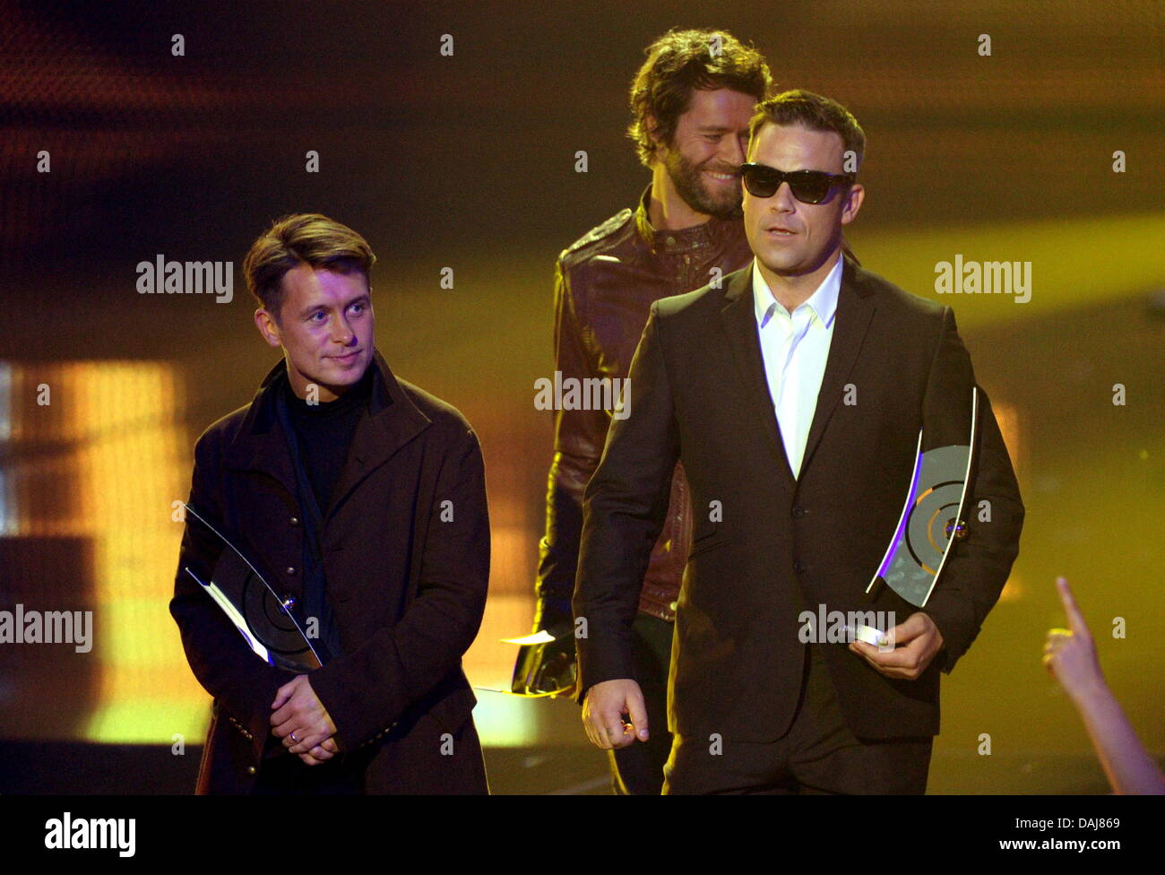 Mark Owen (L-R), Howard Donald et Robbie Williams (C) du groupe britannique prendre que recevoir l'Echo 2011 Music Award dans la catégorie meilleur groupe international à la 20e cérémonie de remise des prix de l'écho à Berlin, Allemagne, 24 mars 2011. Le prix de la musique de l'écho est présentée dans 25 catégories. Photo : afp/lbn Stache Soeren Banque D'Images