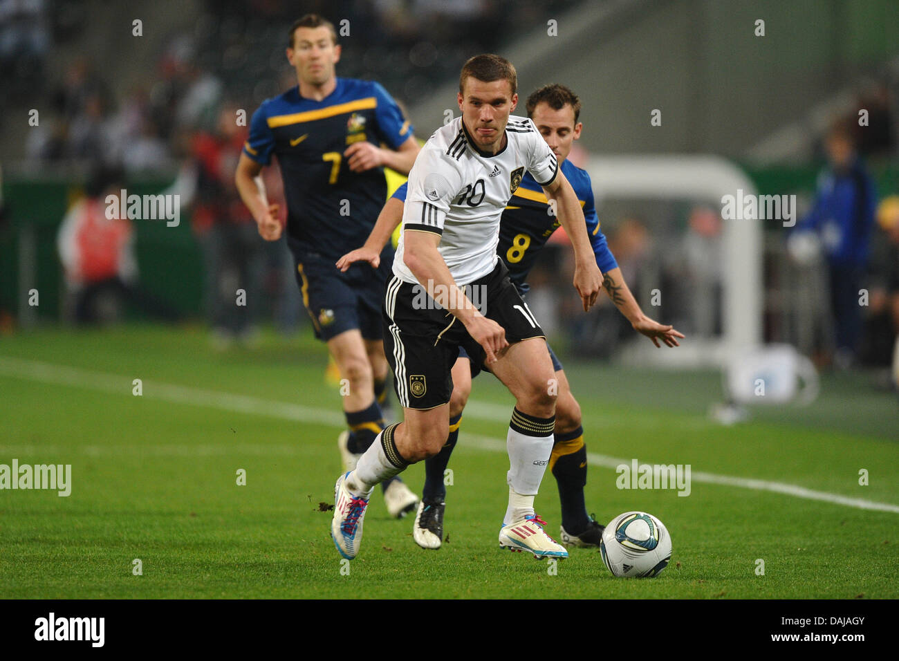 L'Allemagne Lukas Podolski (EDDV) avant de la balle avec l'Austrialia Luke Wilkshire et Brett Emerton (L) au cours de la match amical contre l'Allemagne à la Borussia-Park-Stadium à Moenchengladbach, Allemagne, 29 mars 2011. Photo : Revierfoto Banque D'Images