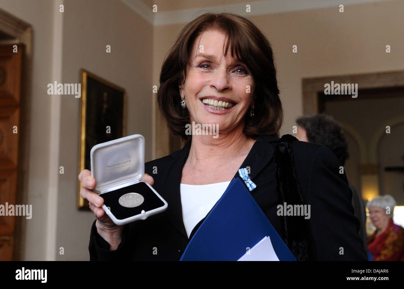 L'actrice Senta Berger tient sa médaille en argent dans sa main après l'attribution de la Médaille de la Constitution bavaroise à Munich, Allemagne, 30 mars 2011. Le destinction a été décerné depuis 1961 en guise de reconnaissance pour son travail d'une personne pour le bien commun. Photo : Tobias Hase Banque D'Images