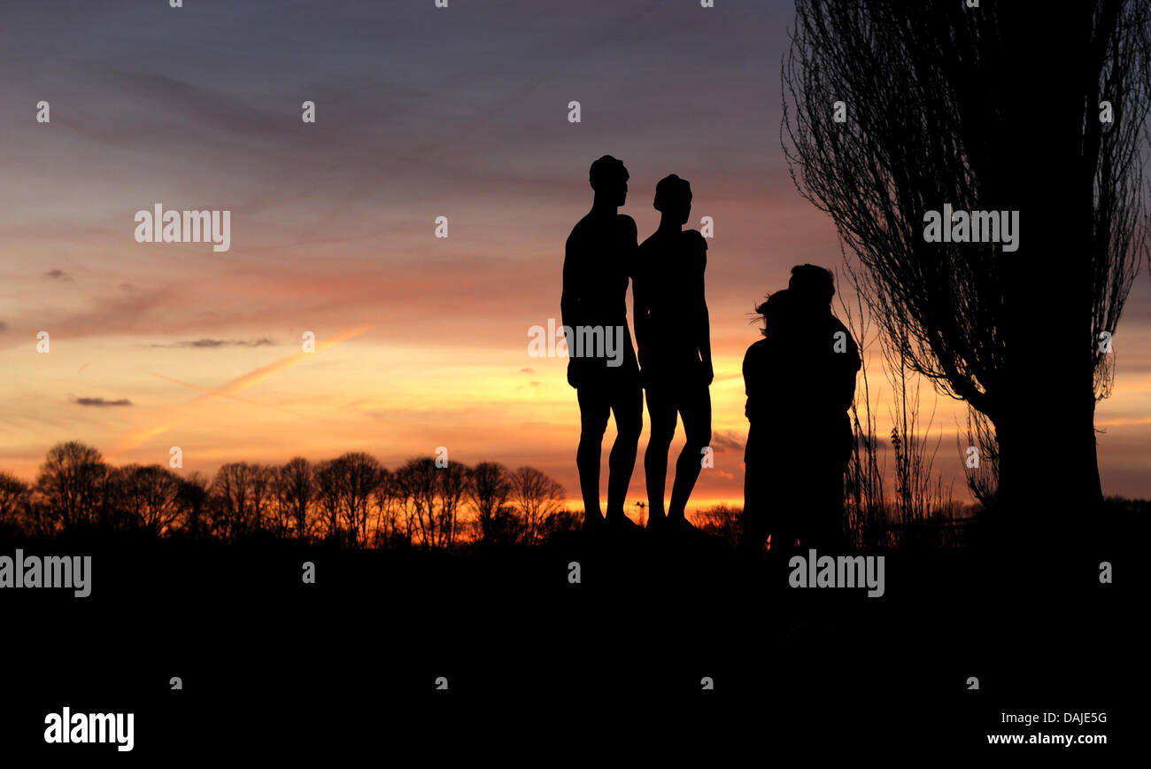 La silhouette d'un couple et de l'œuvre 'Couple' (1939) de l'artiste Georg Kolbe se profilent au coucher du soleil, à Hanovre, Allemagne, le 7 avril 2011. Prévisions météorologistes météo ensoleillée pour le week-end. Photo : Julian Stratenschulte Banque D'Images