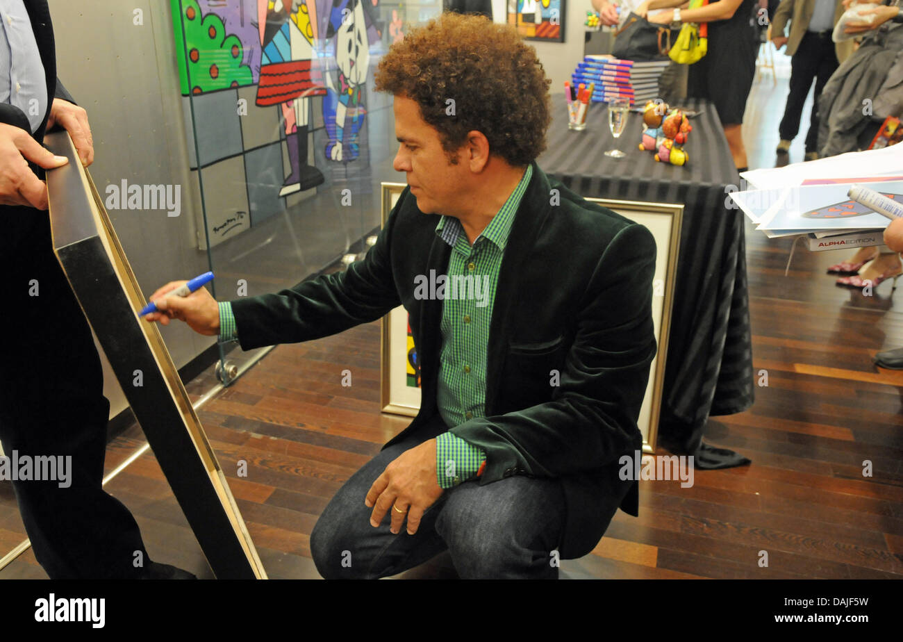 Pop art brésilien Romero Britto, artiste peintre et sculpteur signe une de ses toiles à la Galerie Mensing à Hambourg, Allemagne, 10 avril 2011. Photo : HORST OSSINGER Banque D'Images