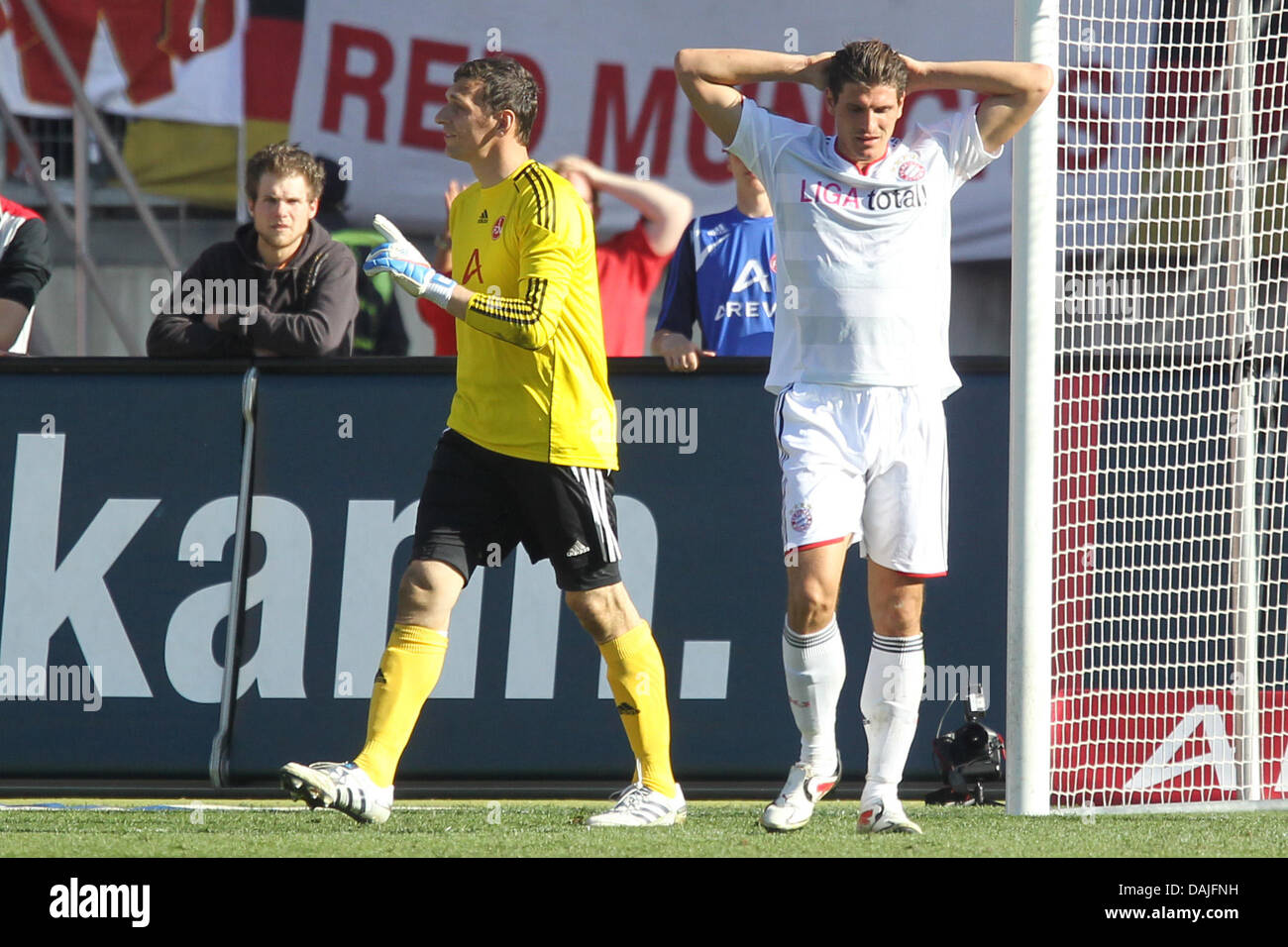 La Munich Mario Gomez (R) est déçu après une tentative échouée alors que Nuremberg gardien Raphael Schaefer (L) est plutôt heureux au cours de la Bundesliga match 1. FC Nuremberg contre le FC Bayern Munich au stade easycredit à Nuremberg, Allemagne, 09 avril 2011. Le match se termine par un nul 1-1. Photo : Daniel Karmann Banque D'Images