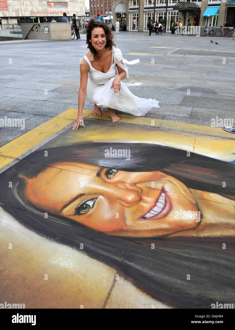 Singer Isabell Varell s'assoit à côté d'un portrait à la craie de Kate Middleton, la future épouse du Prince William, sur le terrain en face de la cathédrale au cours de la production d'une vidéo à Cologne, Allemagne, 11 avril 2011. Varell est en train de produire une vidéo pour sa chanson "Es ist nicht leicht Prinzessin zu sein" ("Ce n'est pas facile d'être une princesse'). Photo : HENNING KAISER Banque D'Images