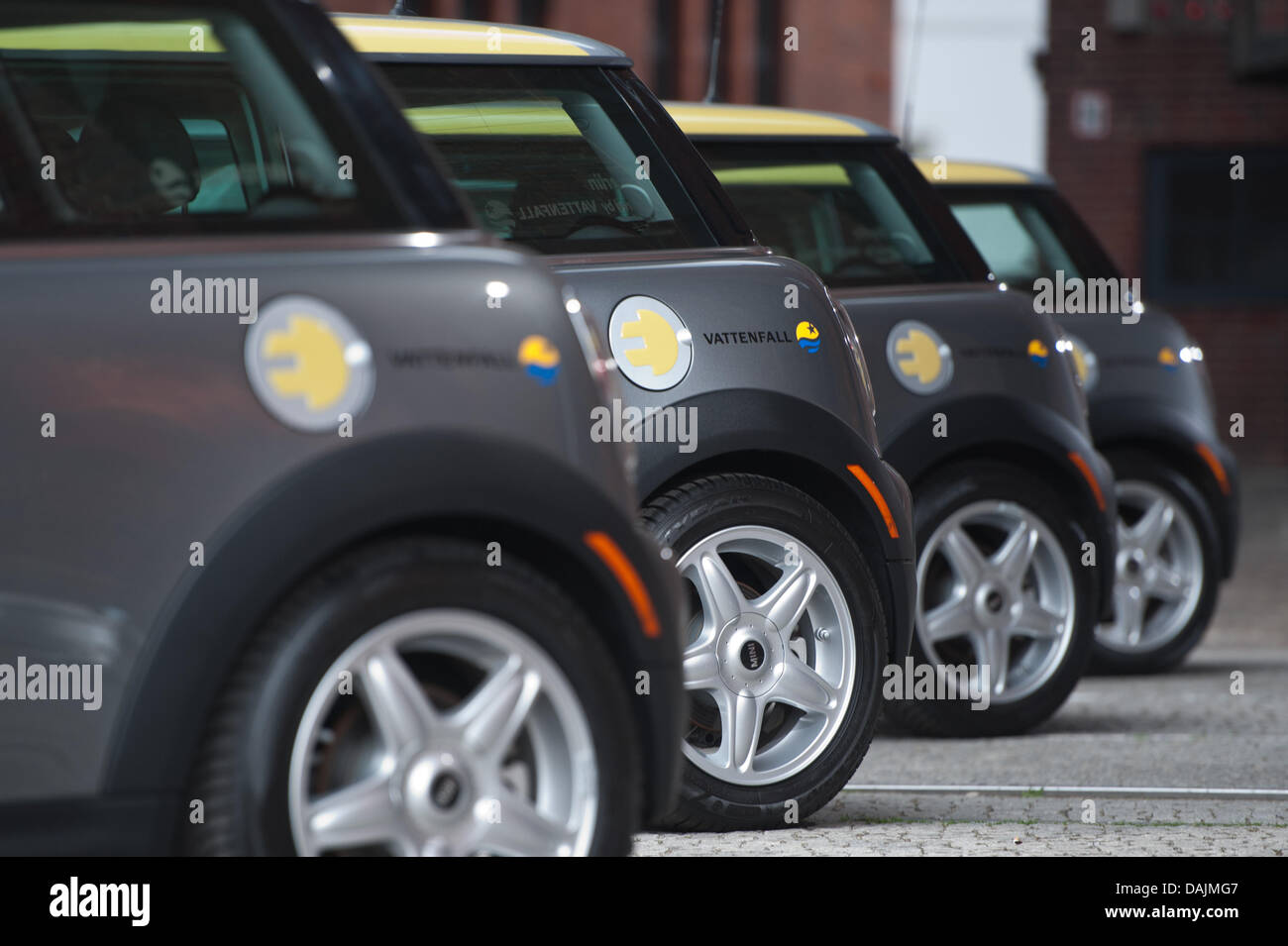 Une rangée de 'Mini' e modèles de voiture par un bouchon de carburant doté d''une fiche d'alimentation et le logo de l'entreprise de fournisseur d'énergie Vattenfall sont affichés lors d'une conférence de presse à Berlin, Allemagne, 31 mars 2011. Le constructeur automobile allemand BMW et Vattenfall continueront leur projet pilote concernant l'utilisation de ces modèles de voitures électriques dans les centres urbains. Photo : Tobias Kleinschmidt Banque D'Images