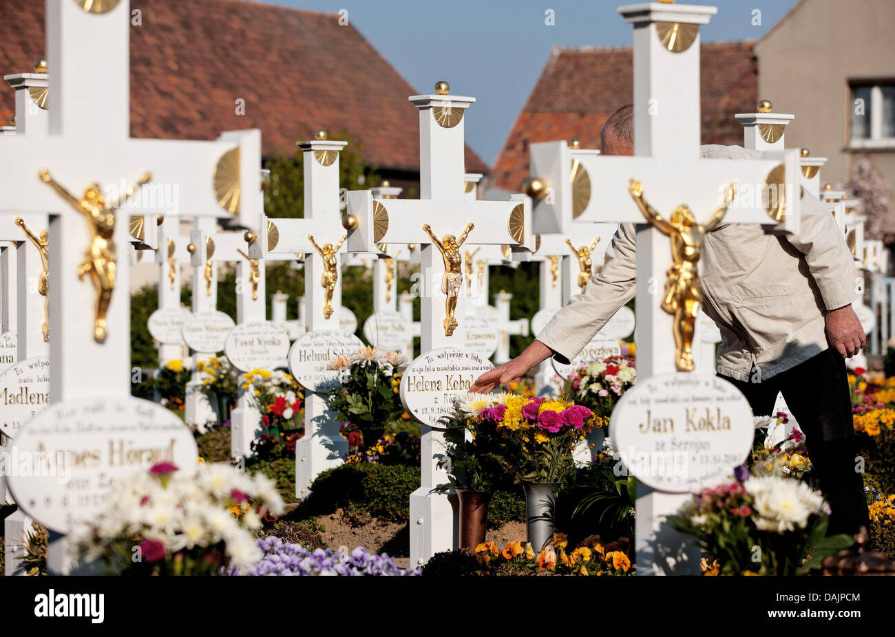 Un homme touche la pierre tombale d'un sur un cimetière en sorabe Ralbitz, Allemagne, 24 avril 2011. C'est une ancienne coutume que des centaines de membres de la minorité sorabe dans la Lausitz pour honorer le Christ. En 1541, les manèges de Pâques ont été mentionnés pour la première fois. Photo : Oliver Killig Banque D'Images
