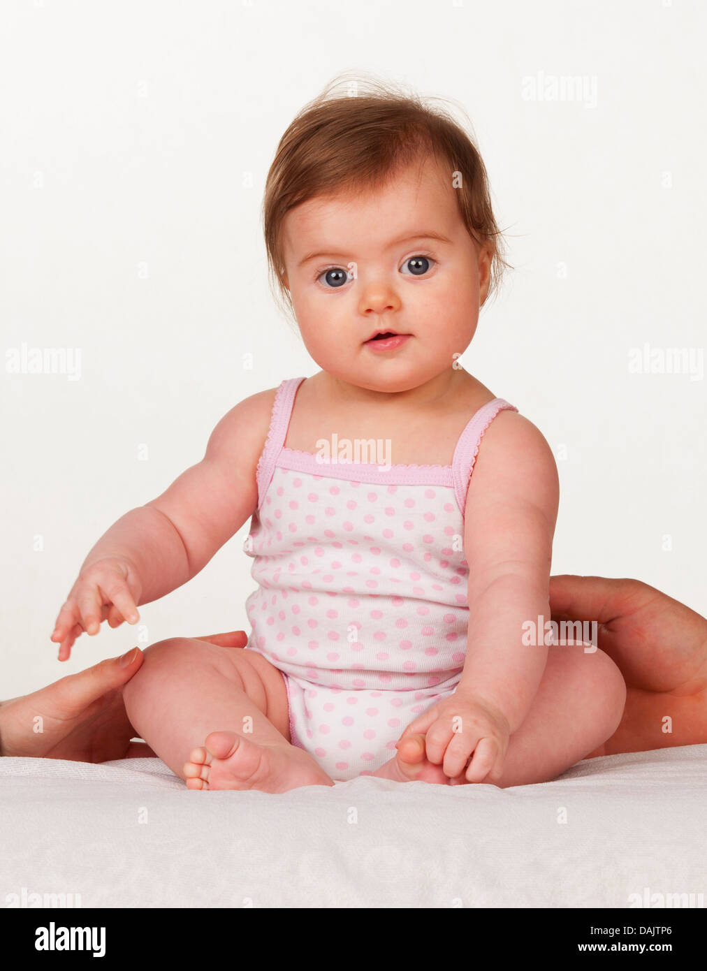 Portrait of baby girl sitting on bed, Close up Banque D'Images