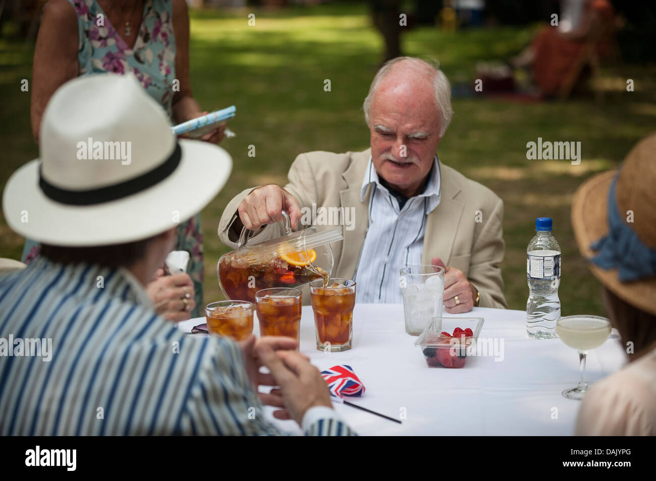 Un homme versant de verres à l'olympiade de Pimms Chaps à Bedford Square Gardens. Banque D'Images