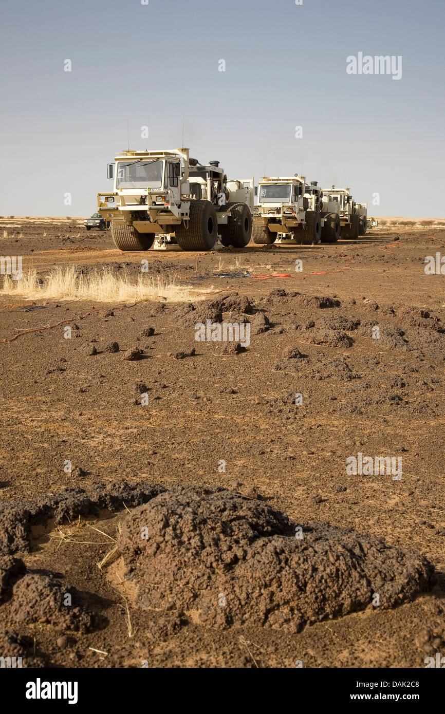 L'exploration du pétrole au Mali. Vibrateur sismique des véhicules se déplaçant à travers désert et frottez le relief levé géophysique de concession. Banque D'Images