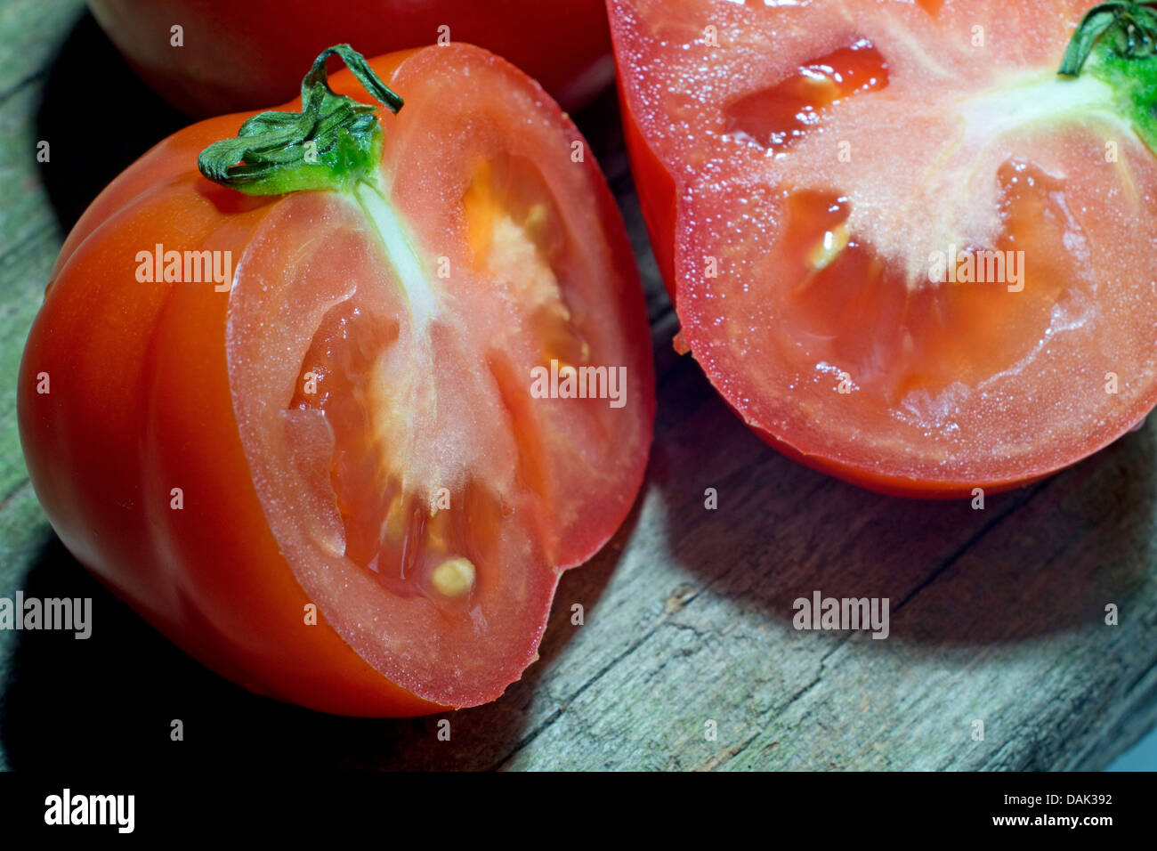 Jardin la tomate (Solanum lycopersicum, Lycopersicon esculentum), allongé sur une planche en bois tranchés Banque D'Images