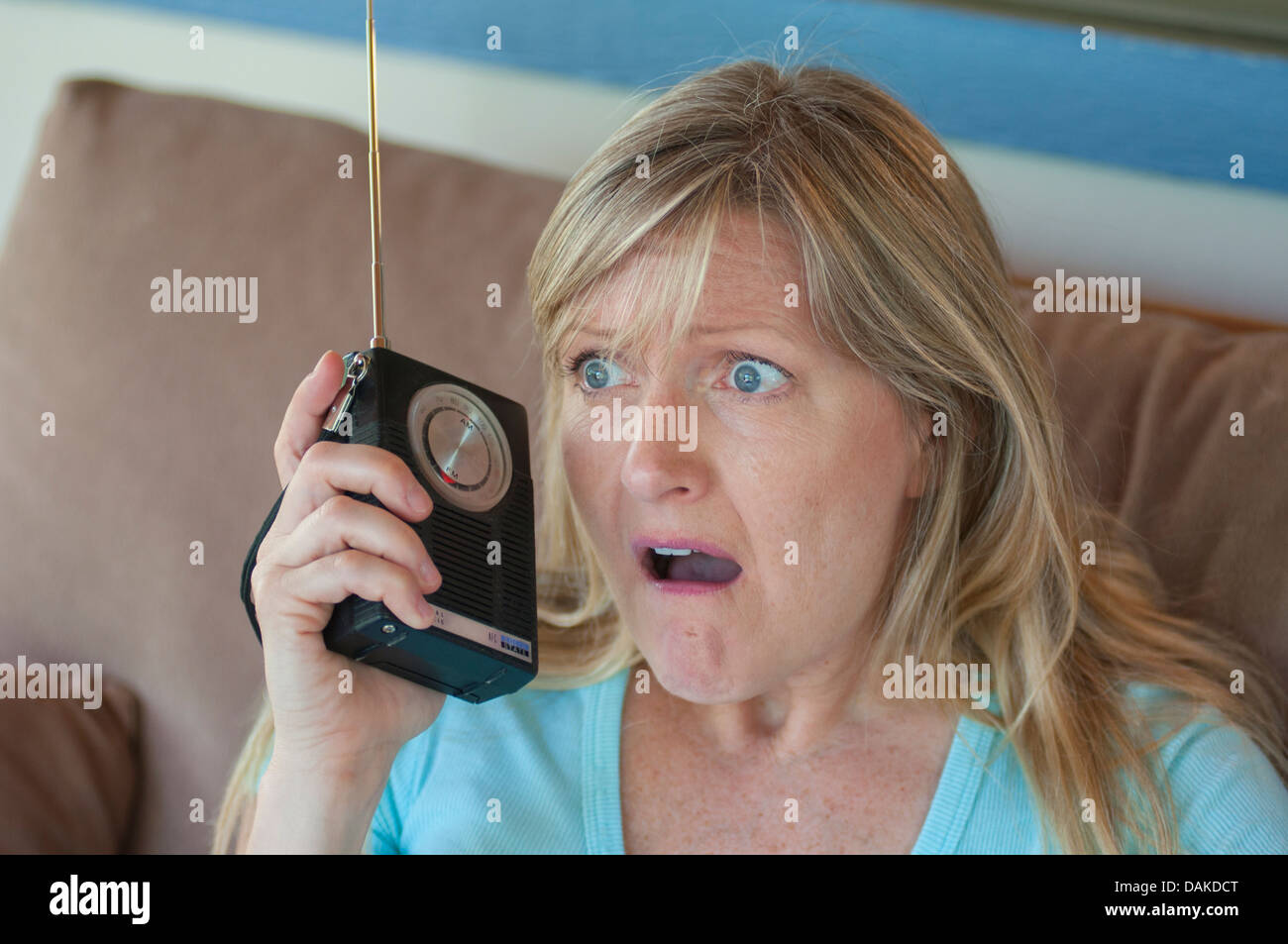 Expression malheureuse femme avec l'écoute de radio à transistors. Banque D'Images