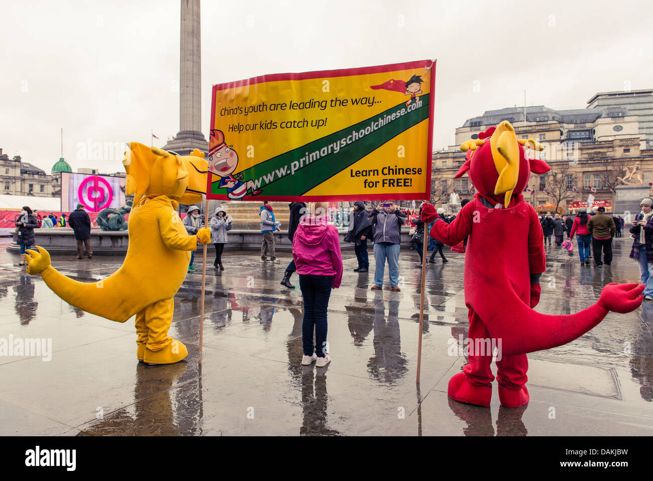 Mascottes holding une bannière pour l'éducation au cours de la London célébrations du Nouvel An chinois 2013 Banque D'Images