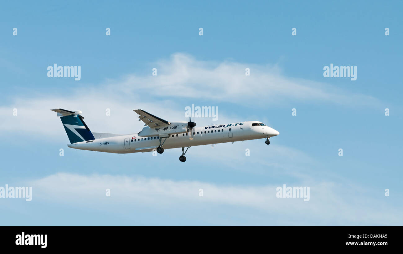 WestJet Encore un biturbopropulseur Q400 Dash 8 avion en vol et en approche finale pour l'atterrissage, l'Aéroport International de Vancouver. Banque D'Images