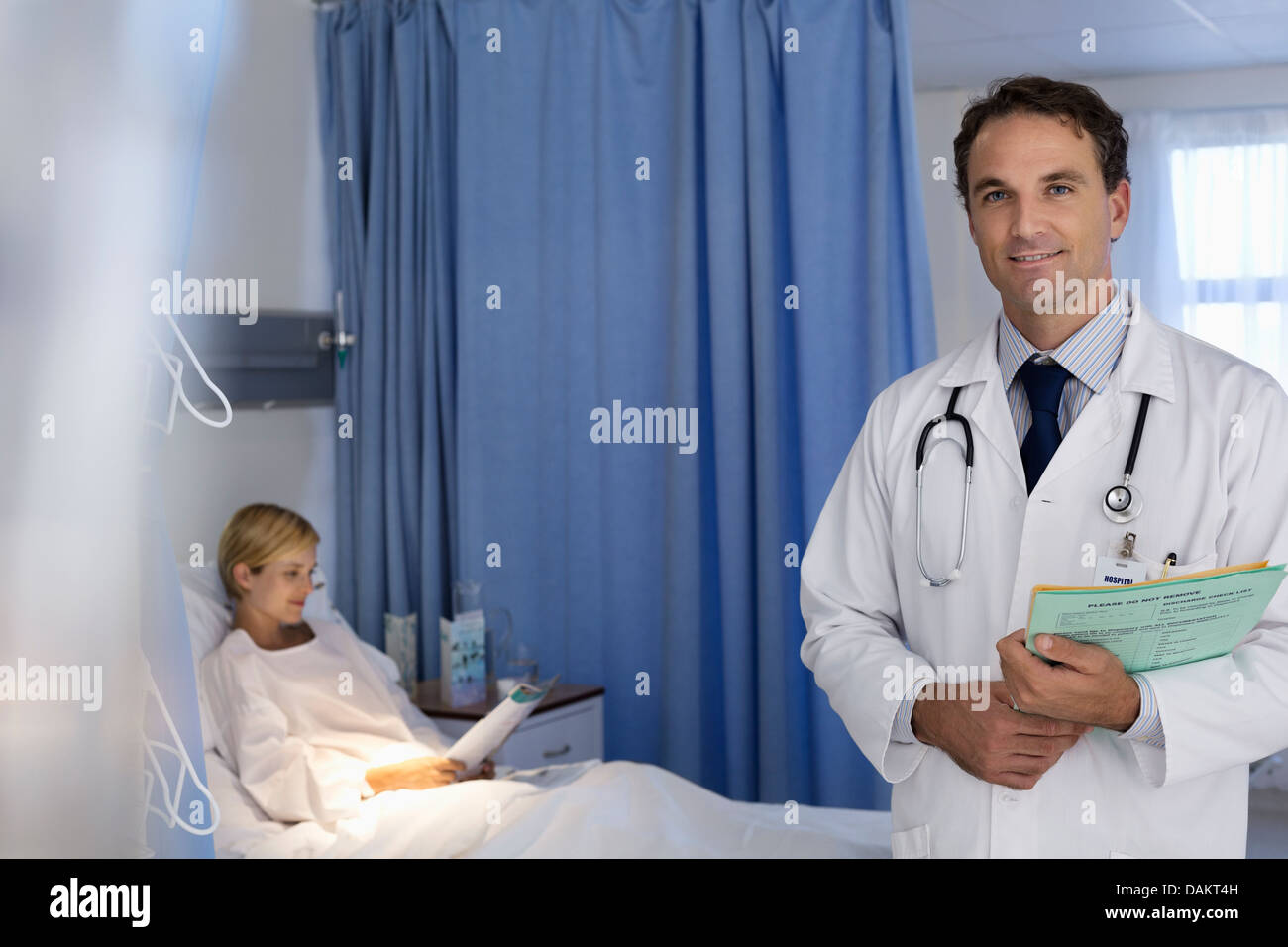 Doctor smiling in hospital room Banque D'Images