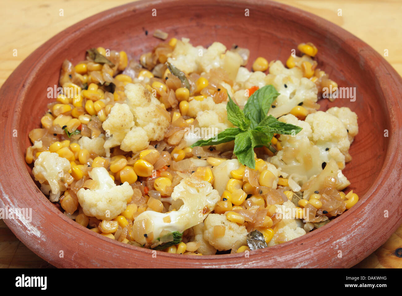 Le maïs et le chou-fleur balti fait maison dans un Indien curry bol en terre cuite Banque D'Images