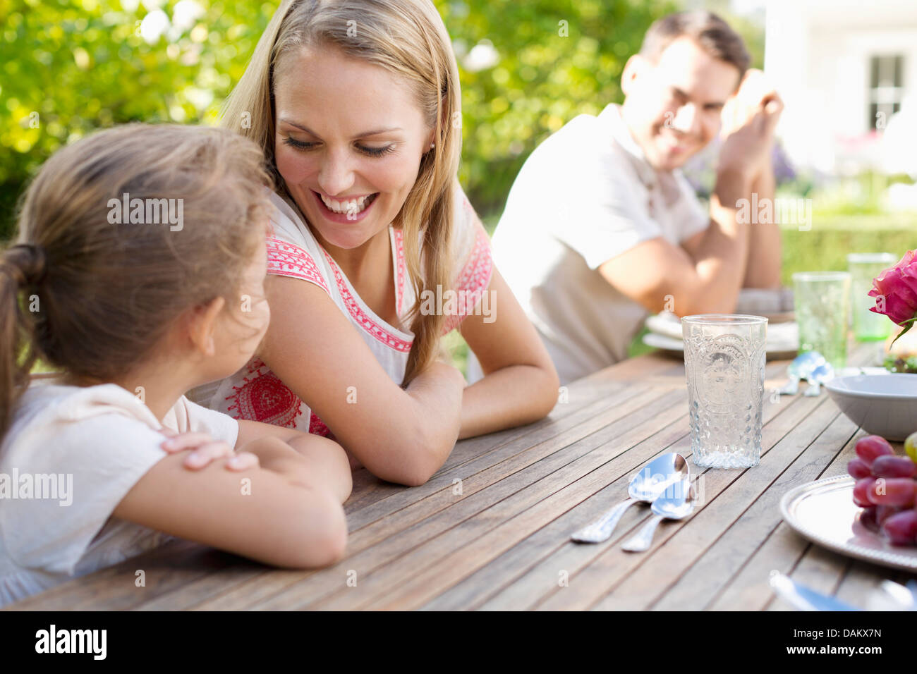 Family sitting at table outdoors Banque D'Images